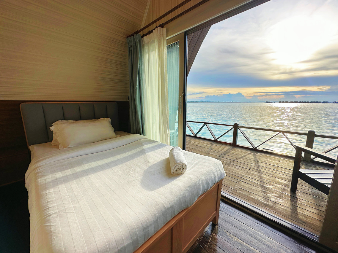 An inviting double bedroom at Crystal Resort with two large beds, modern pink accents, solid wood floors, air conditioning and glass doors