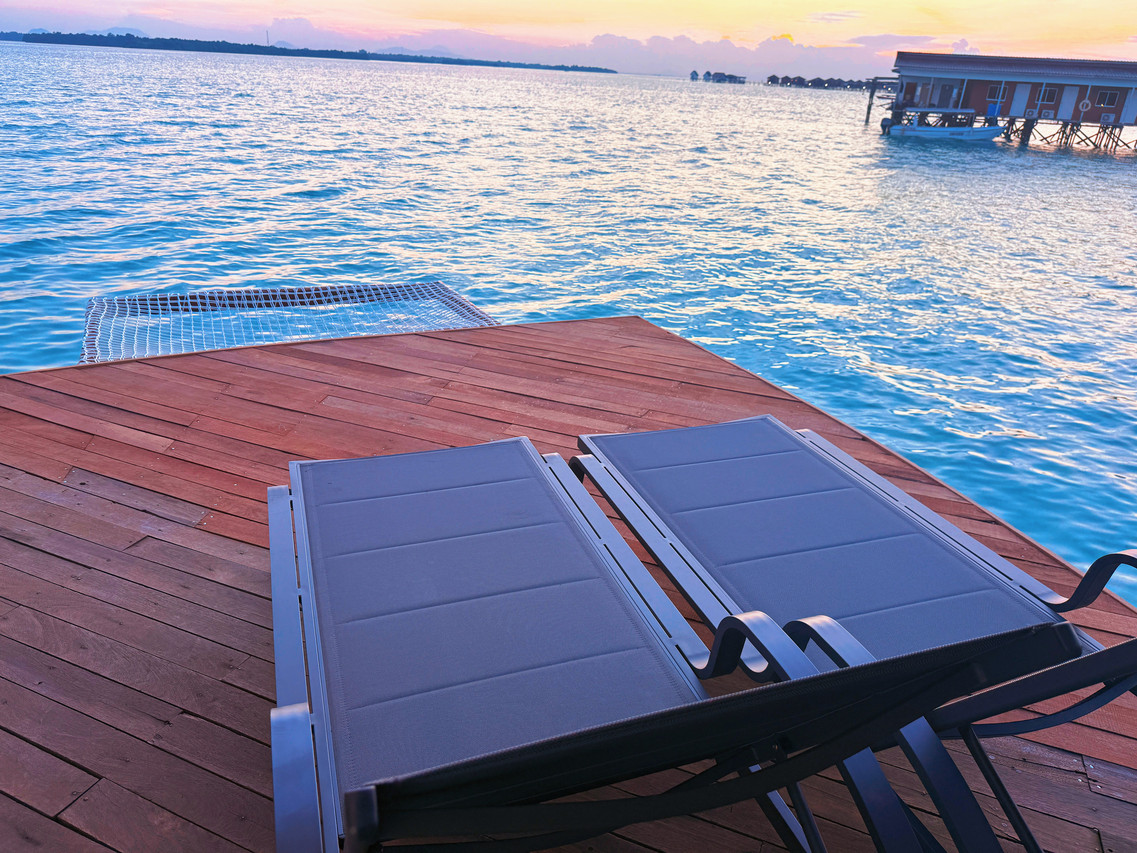 Private sun-soaked balcony with modern loungers at Crystal Resort, with golden hour and gentle sea breeze above the Celebes Sea